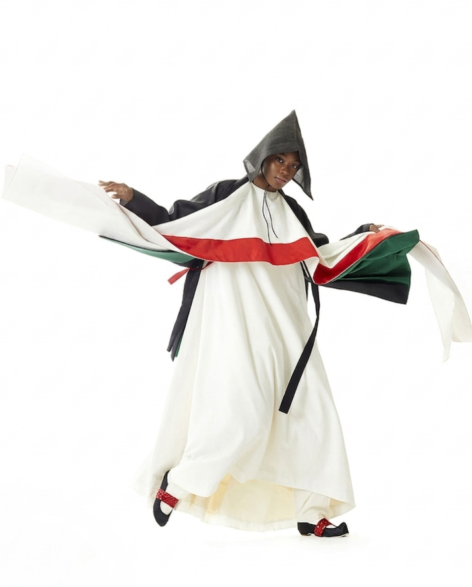 2019 collection — a white robe with a black conical hat, sleeves spread wide