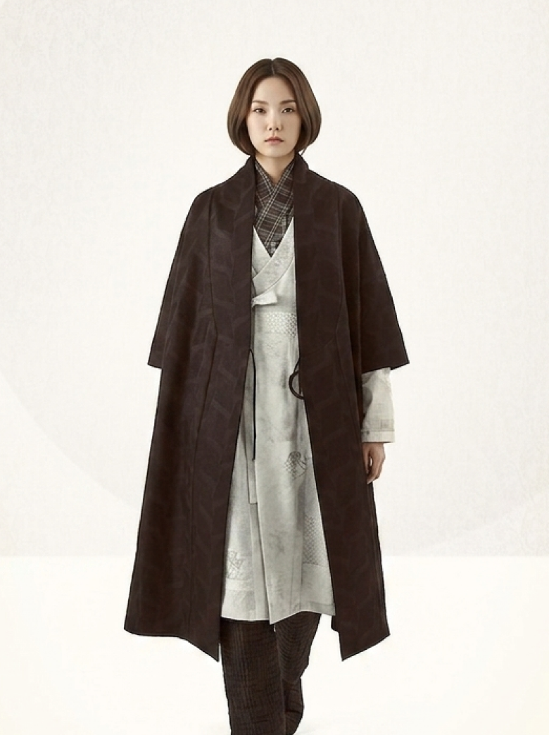 2019 collection — a dark brown wool coat over an ivory shirt and trousers