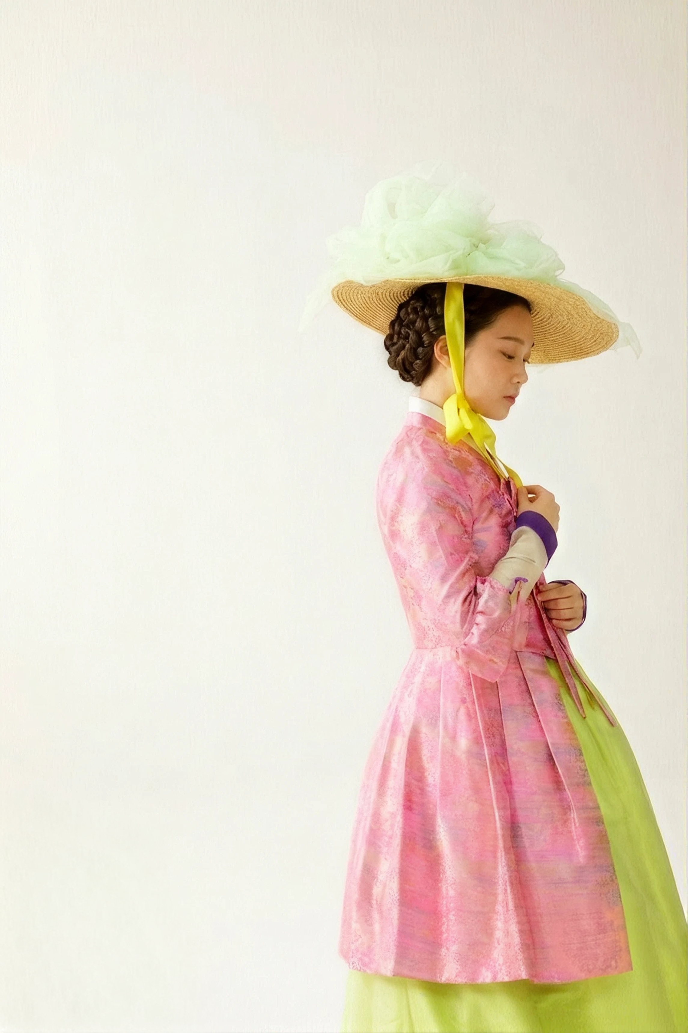 A pink jacquard hanbok with a chartreuse skirt and a wide green hat