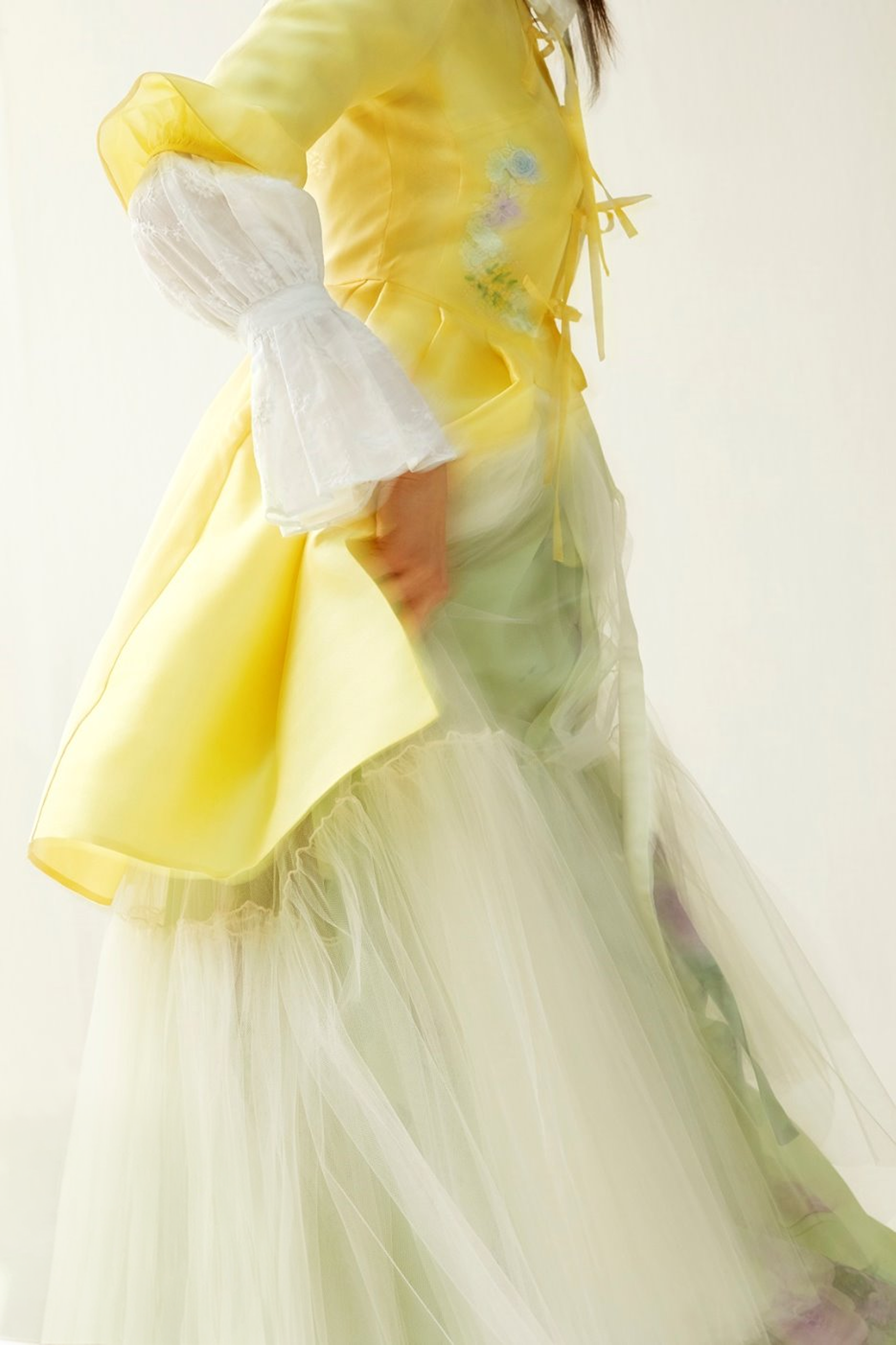 A sheer yellow hanbok gown with a sculpted ribbon shoulder