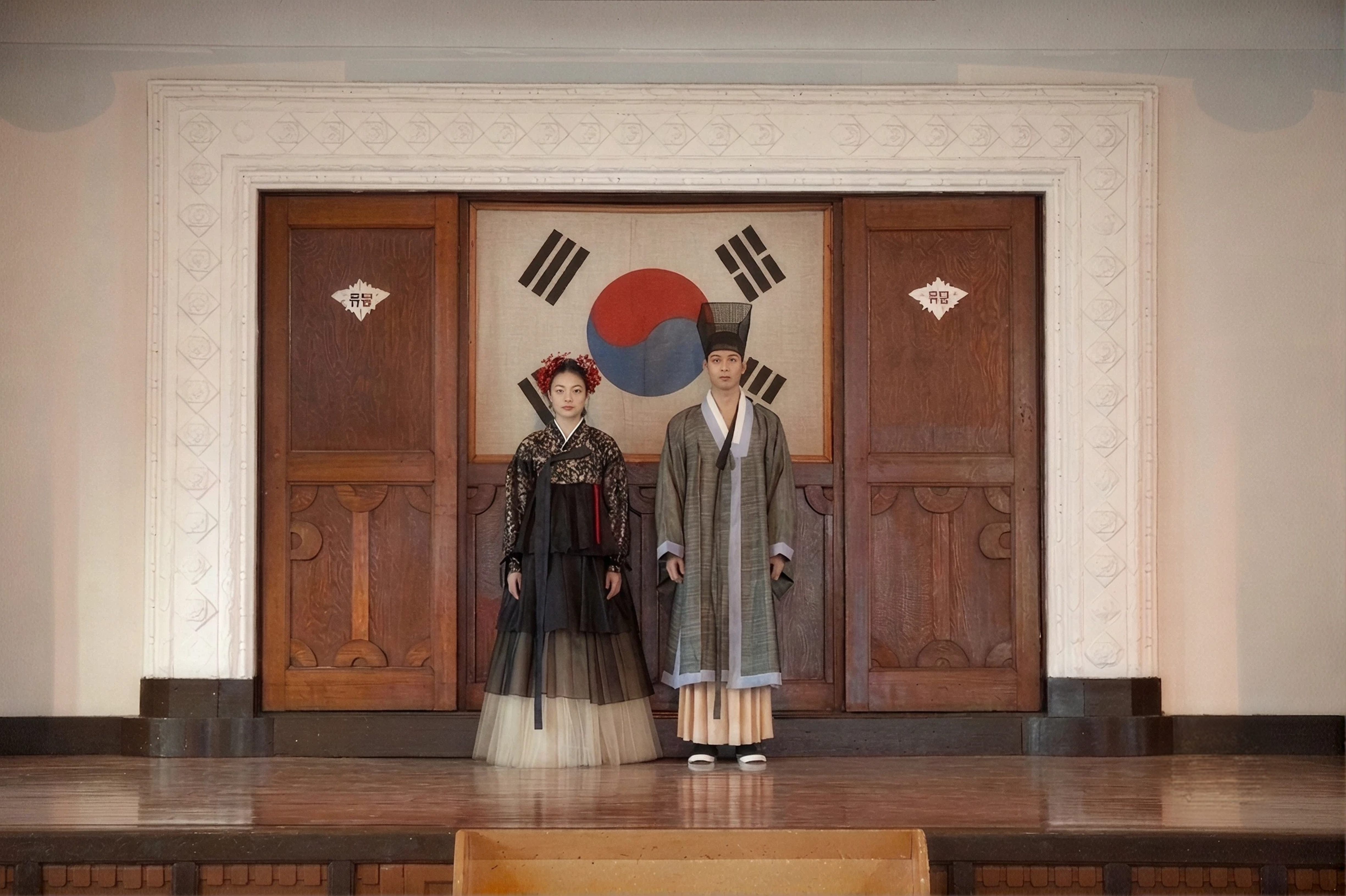 2021 collection — two hanbok looks displayed in a hall beside the Korean flag