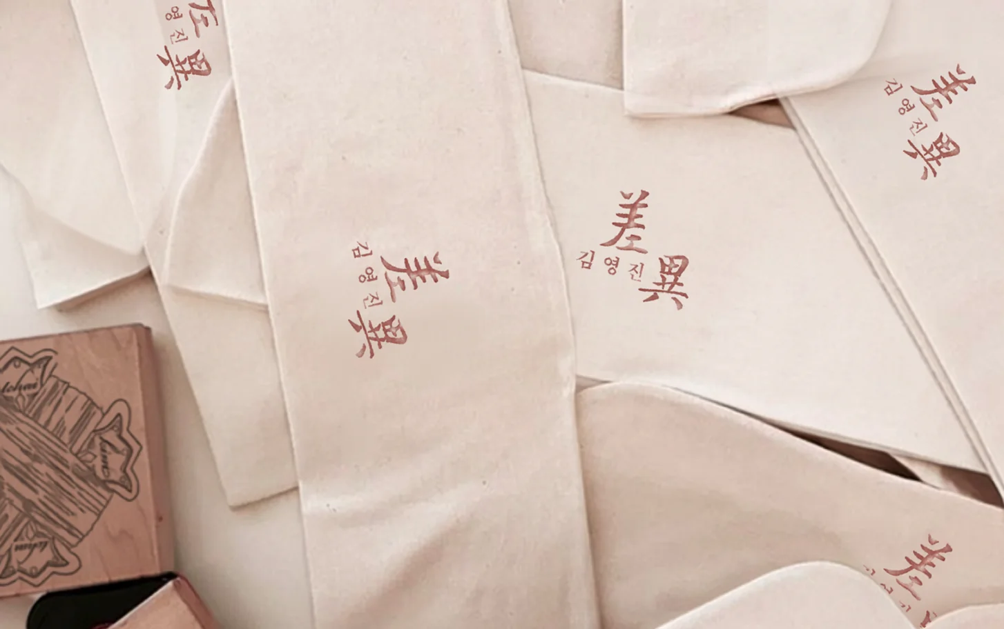 Hand-painted silk hanbok pieces laid out in the atelier