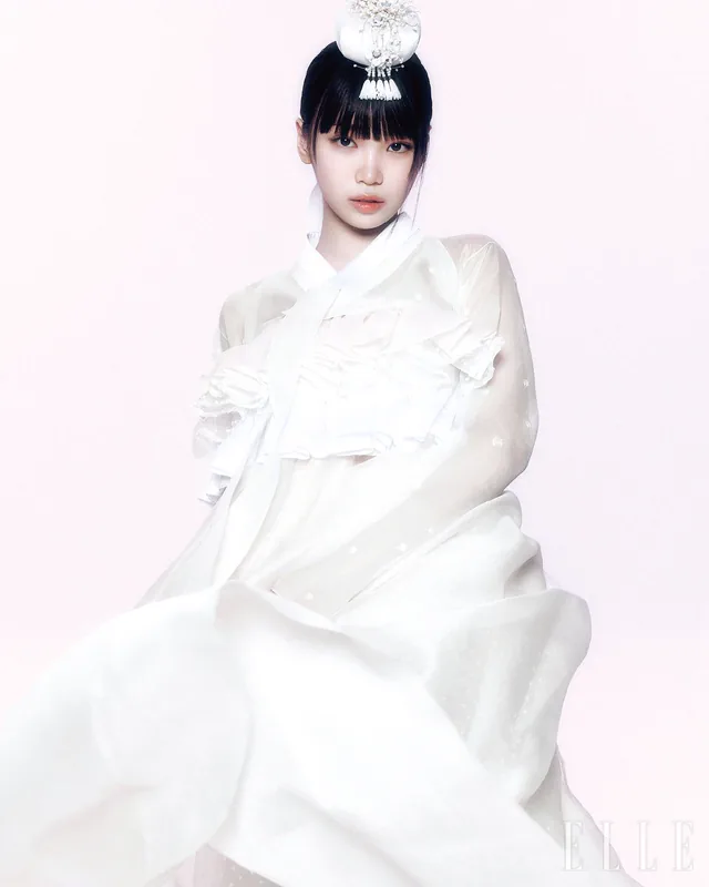 A woman wearing a white sheer hanbok for an editorial portrait