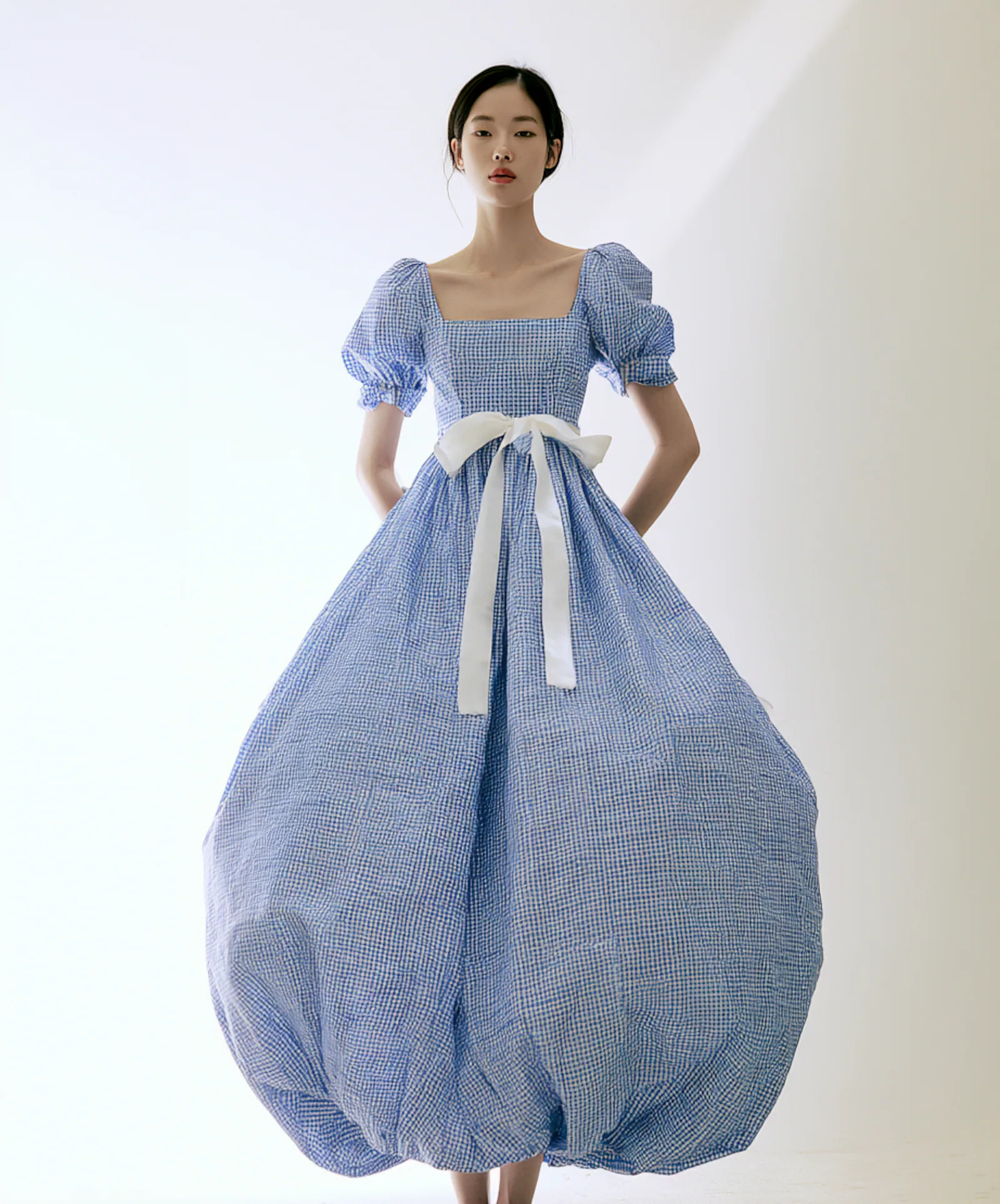 A model wearing the Ruffle Collar Puff Dress, a semi-loose dress with ruffle trim and puff sleeves