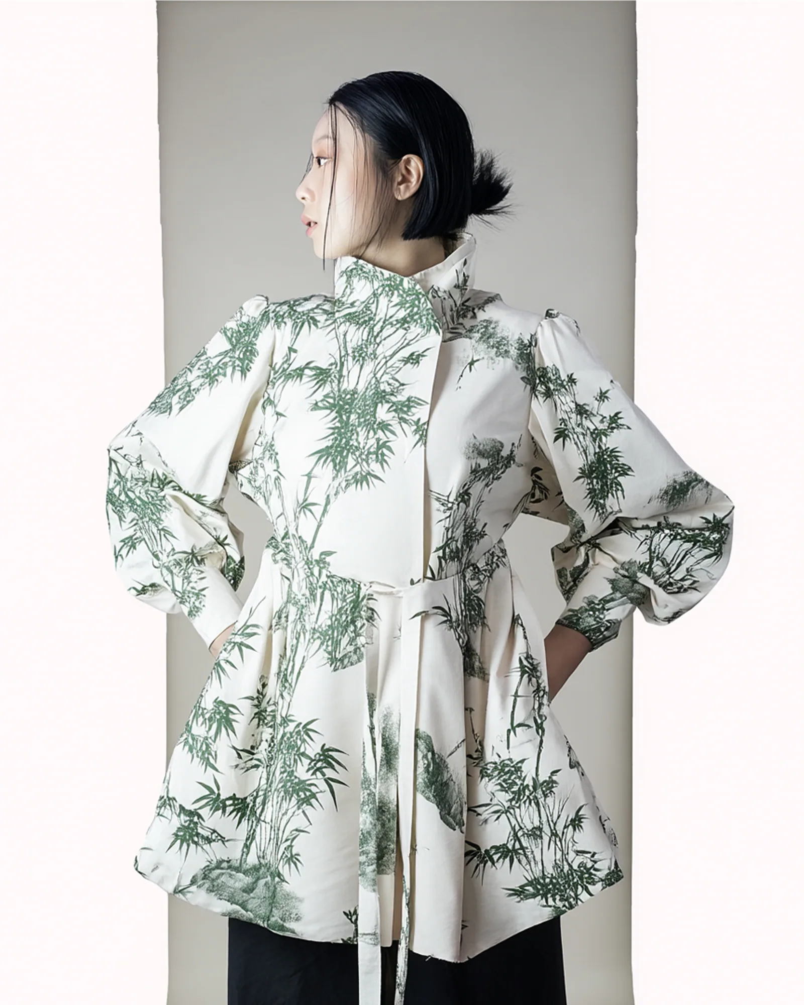 A model wearing the Four Gracious Plants Jeogori Shirt in a plum, orchid, chrysanthemum and bamboo print
